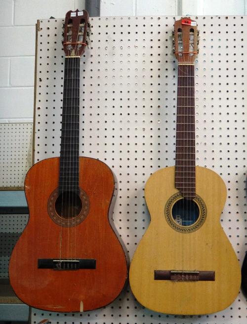 A 20th century six string acoustic guitar and another.