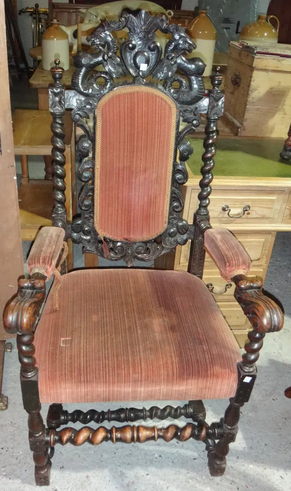 A 19th century oak framed open armchair with profusely carved decoration and padded back and seat.