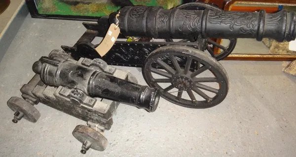 A large cast iron ornamental cannon and another similar.