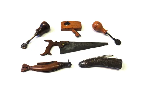 Four early 20th century tools, comprising; two leather punches with turned fruitwood handles, a small plane, and a handsaw of small proportions (24.5c