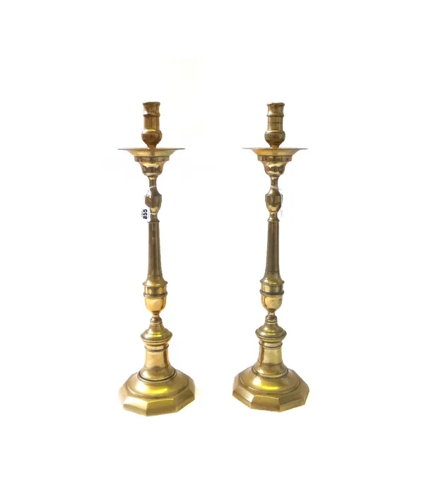 A pair of Victorian brass altar candlesticks, each of turned form, with a wide drip pan and octagonal foot, 64cm high. (2)