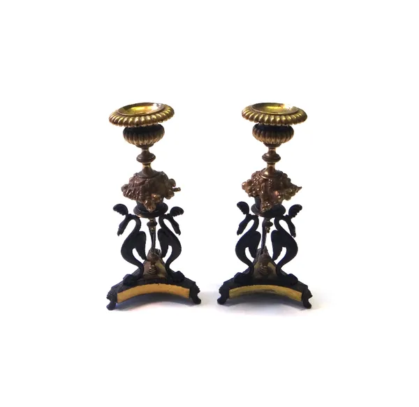 A pair of Regency style gilt and patinated bronze candlesticks, each on triform bases, 21cm high (2).