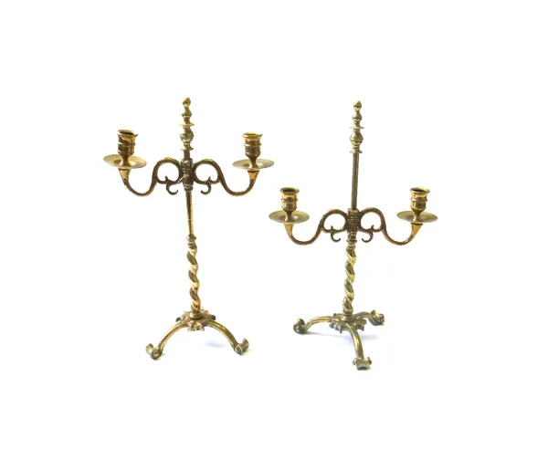 A pair of brass adjustable two branch candlesticks, early 19th century, with barley-twist supports on a triform base, 42cm high, (2).