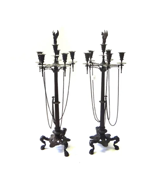A pair of French bronze six branch candelabra, 19th century, with a griffin type snuffer finial over a fluted tapering stem issuing five foliate cast