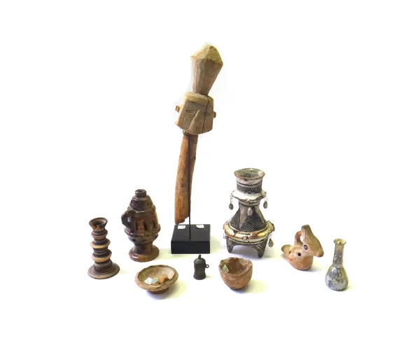 A group of antiquities, comprising; a terracotta candlestick, 12cm high, a tribal wooden mask on a stand, a small Roman glass bottle, a small bronze j