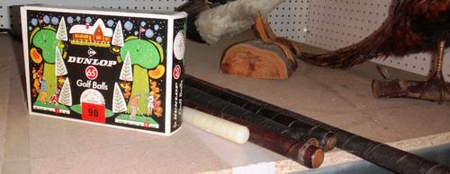 A box of Dunlop 65 golf balls, four hickory shafted golf clubs, and associated pieces (qty).