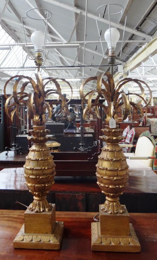 A pair of giltwood and metal worked table lamps with "palm tree" carved bodies on square bases, 65cm high excluding fitments (2).