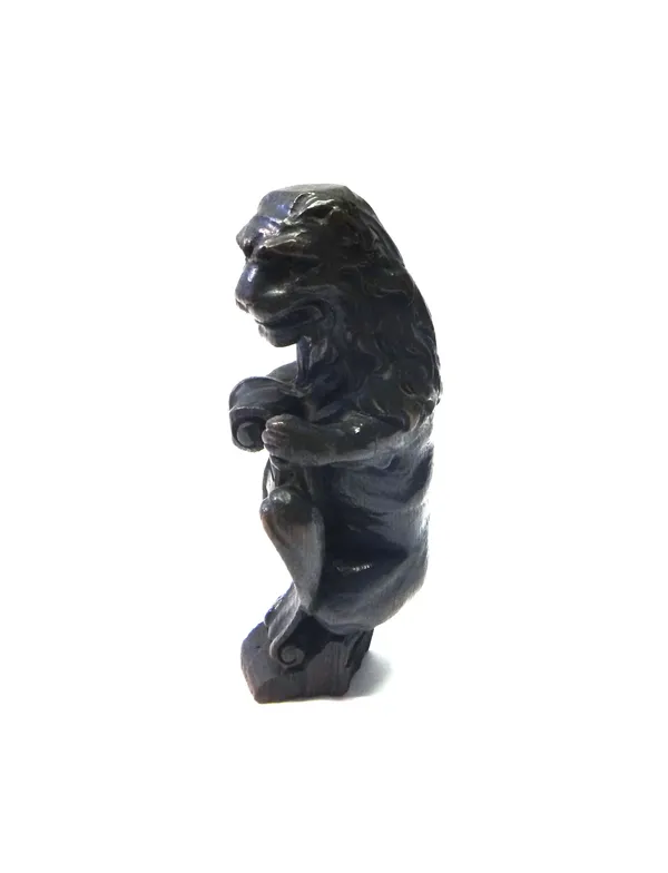 A carved oak surmount, 18th century, modelled as a lion holding a shield, 31cm high.