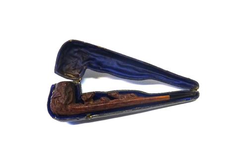 A Black Forest carved wooden pipe, late 19th century, detailed to the shaft with a fox and hound, and hunting paraphernalia to the bowl, with a velvet
