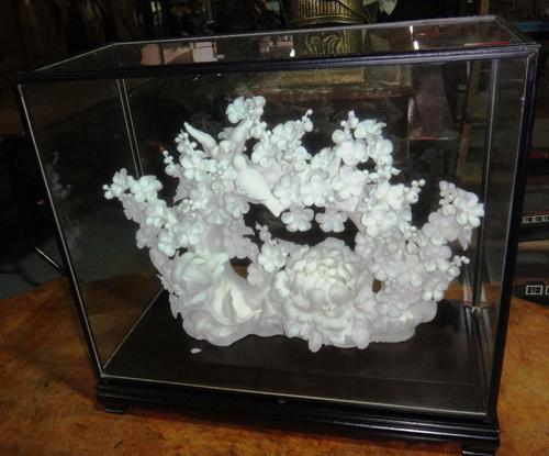 A 20th century Oriental porcelain model of flowers and birds, contained in an ebonised glass case.