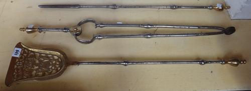 A set of three steel and brass mounted fire tools and a steel serpentine fender, 116cm wde. (4)