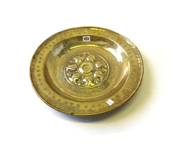 A Nuremberg brass alms dish, 16th century with raised stylized flowerheads and a band of script within a wide foliate border, 40cm diameter and anothe