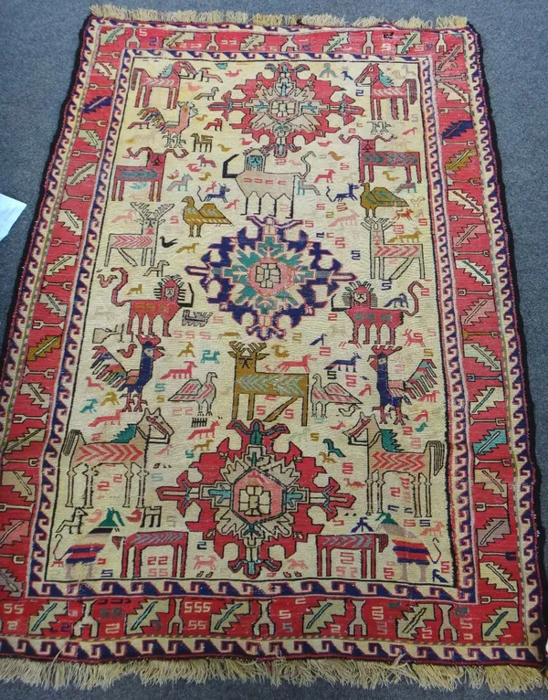A silk soumak rug, the 'gold' field with three medallions and animals, 130cm x 91cm.