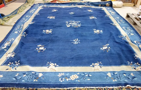 A Chinese carpet, the dark indigo field with delicate floral sprays, a pale indigo floral spray border, 384cm x 314cm.