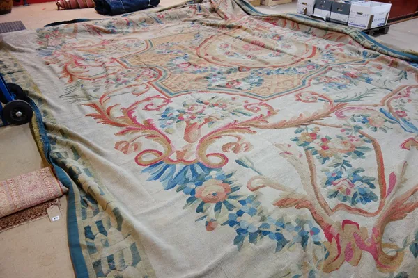 An Aubusson carpet, the beige field with a large central medallion, floral sprays to corners, a leaf border, 590x 500cm.