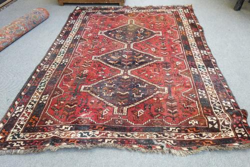 A Shiraz carpet, South Persian, the madder field with three diamonds, all with birds and flowers, various borders, 250cm x 184cm.