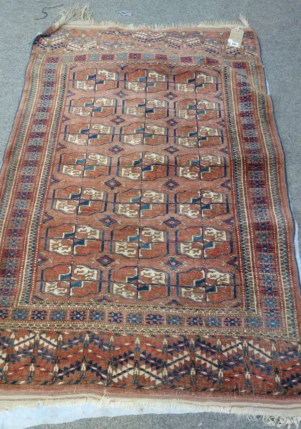 A Tekke Turkman rug, the madder field with three columns of seven guls, a hooked motif border, plant ends, 140cm x 96cm.