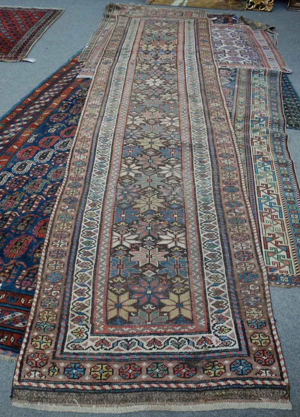 A North West Persian runner, the brown field with a bold flowerhead pattern, with three borders, 360cm x 89cm.
