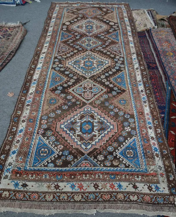 A North West Persian runner, the brown field with six medallions, supporting half medallions, with three borders, 262cm x 106cm.