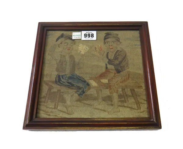 An early Victorian needlework picture depicting two young boys playing cards astride a bench (19.5cm x 18.5cm), together with a still life depicting f
