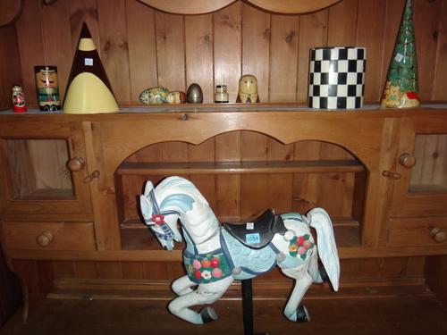A group of decorative wooden items, including a carved model of a horse, incomplete Russian style dolls and sundry wooden items.