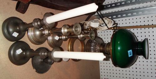 A Victorian brass adjustable oil lamp with green glass shades and a group of candlesticks.