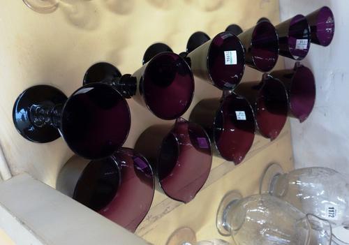 A set of six amethyst coloured wine glasses, 19th century, each with tapering bowl and knopped stem, 13cm high, and five matching rinsing bowls (11).