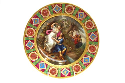 A Vienna style cabinet plate, late 19th century, painted with 'Armida and Rinaldo' within a gilt and multicoloured wide border, underglaze blue shield