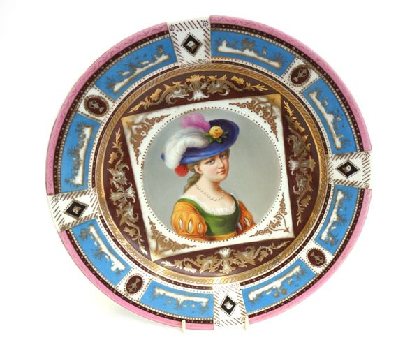 A Vienna style dish, early 20th century, painted with a bust portrait of a lady in a plumed hat within a gilt, pink and blue panelled border, with spu