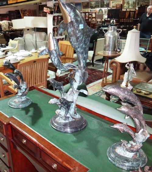 A 20th century bronze figure group of dolphins, on a naturalistic base, together with two similar small bronze models.