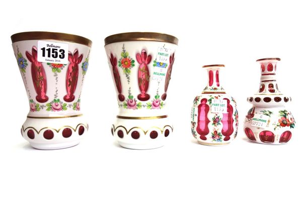 A pair of Continental cranberry and enamel overlaid glass vases with painted floral decoration, 13cm high, and two small cranberry and enamel vases of