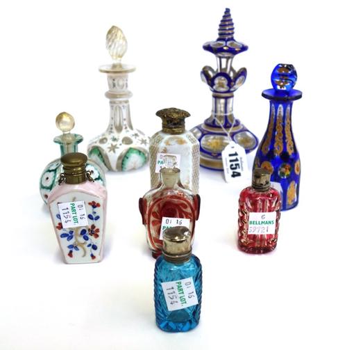 A Victorian glass and blue enamel overlaid scent bottle and stopper, 14.5cm high, a smaller scent bottle with white enamel overlay, and seven other sm