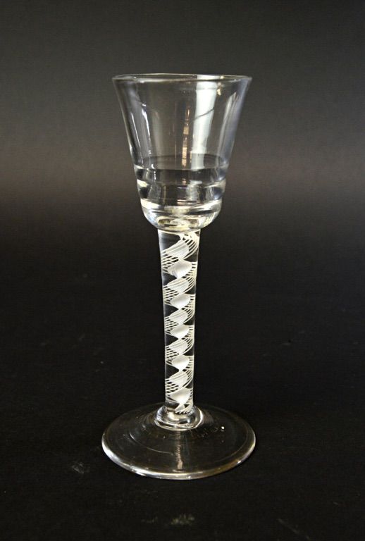 An English 'Lynn' type wine glass, circa 1765, with rounded funnel stepped bowl and double series opaque twist stem, on a circular foot, 15.6cm high.