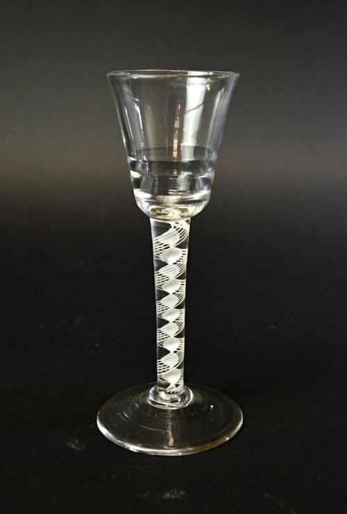 An English 'Lynn' type wine glass, circa 1765, with rounded funnel stepped bowl and double series opaque twist stem, on a circular foot, 15.6cm high.