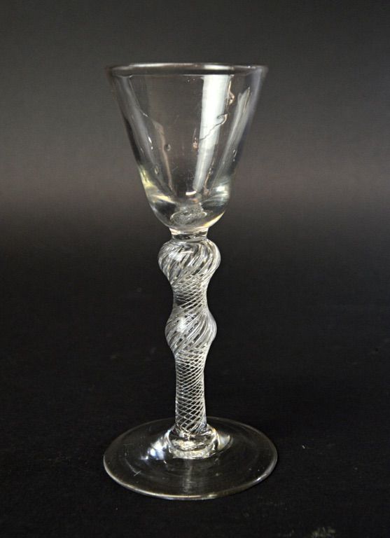 An English wine glass, circa 1750, with rounded funnel bowl and double knopped air twist stem, on a circular foot, 15.2cm high.  Illustrated