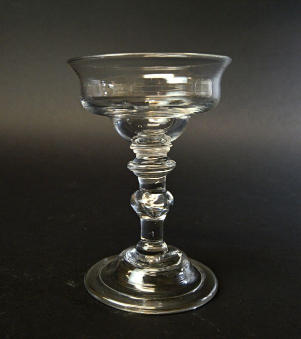 An English glass sweetmeat, probably 18th century, with an annulated knop, inverted baluster stem and raised circular foot, 15cm high.  Illustrated