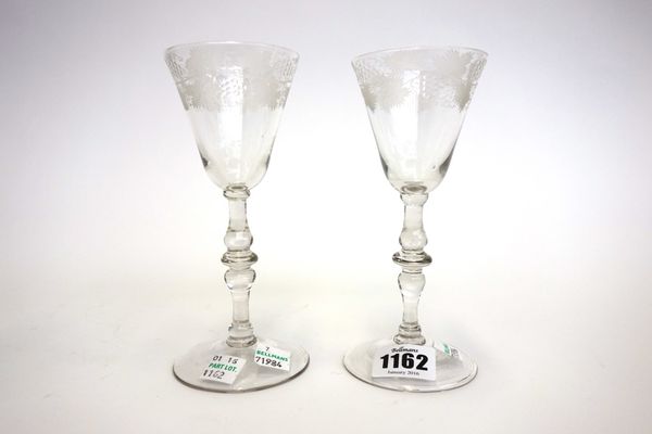 A pair of English engraved wine glasses, circa 1750, each with a rounded funnel bowl and 'Newcastle' light baluster stem, on a circular foot, 16cm hig
