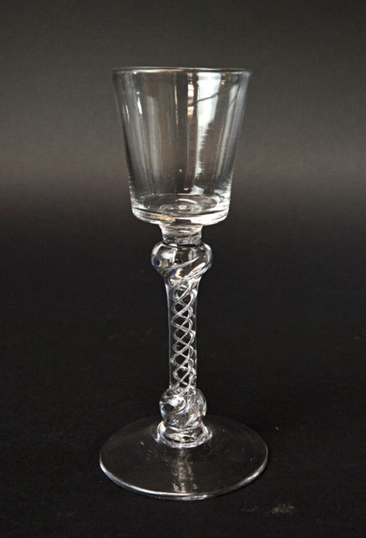 An English wine glass, circa 1750, with bucket bowl and double knopped air twist stem, on a circular foot, 15.7cm high.  Illustrated