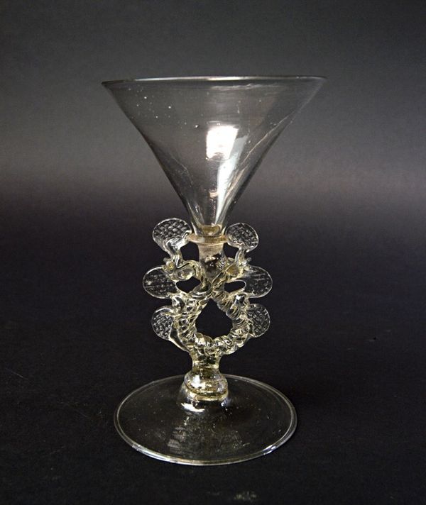 A Facon de Venise wine glass, with funnel bowl over serpentine stem and pierced wings, on a circular foot, 16cm high.  Illustrated