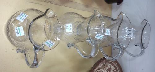 Four English engraved glass jugs, late 18th/early 19th century, the tallest 21cm, each with folded rim, foliate etched decoration and a circular foot