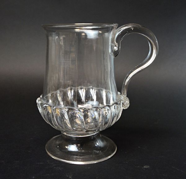 An English glass coin tankard, late 18th century, with a gadrooned base and raised circular foot enclosing a George II old head silver shilling dated