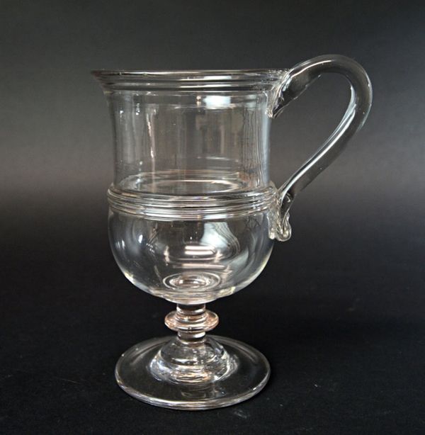An English glass tankard, late 18th/early 19th century, with triple reeded rim and band to the body, raised on a knopped stem and circular foot, 17.5c