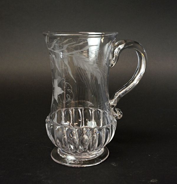 An English glass ale tankard, late 18th century, the waisted body engraved with hops and initialed 'I.B.', with gadrooned decoration and a circular fo