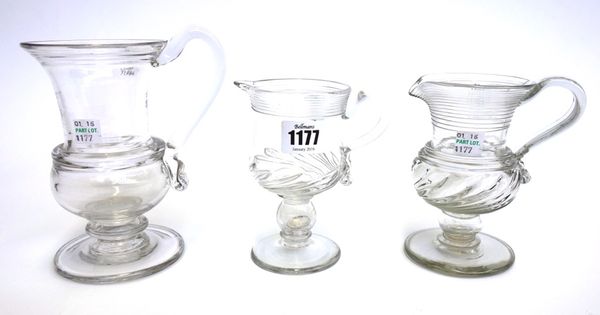 An English glass coin jug, early 19th century, with trailed decoration to the rim, gadrooned base and a hollow knopped stem enclosing a George III sil