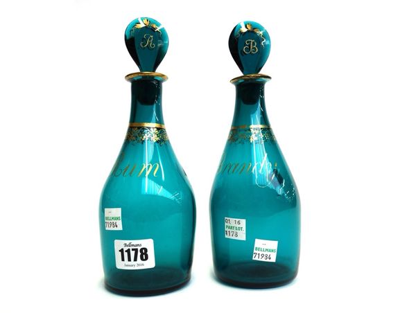 A pair of English green glass decanters and stoppers, late 18th century, each gilt decorated with fruiting vine and titled 'Rum' and 'Brandy', 22cm hi