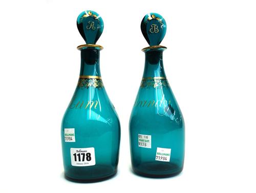 A pair of English green glass decanters and stoppers, late 18th century, each gilt decorated with fruiting vine and titled 'Rum' and 'Brandy', 22cm hi