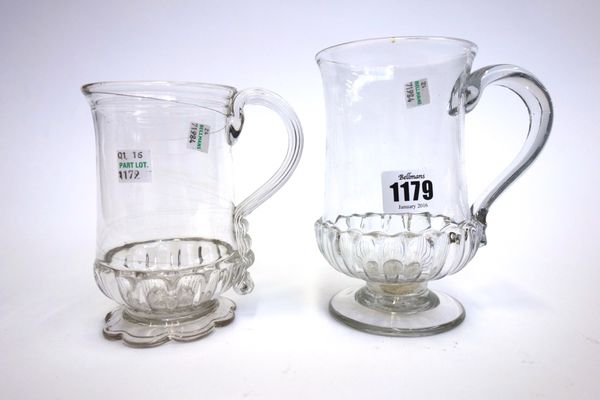 An English glass tankard, late 18th century, with triple reeded rim, gadrooned body and shaped foot, 13.6cm high, and a larger glass tankard with simi