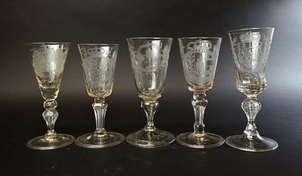 Five German engraved armorial goblets, 18th century, Bohemia, Saxony, each on faceted moulded silesian stem and folded foot, the tallest 21.7cm high.