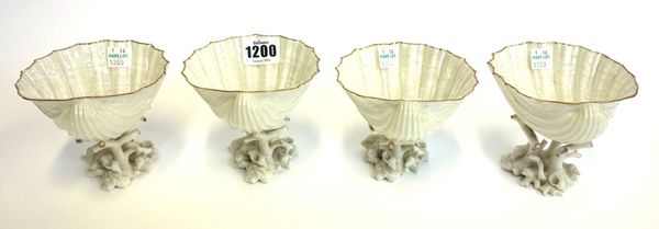 A set of four Beleek porcelain sweetmeat dishes, each bowl of shell form, raised on coral supports, black printed mark, 9cm high (4).