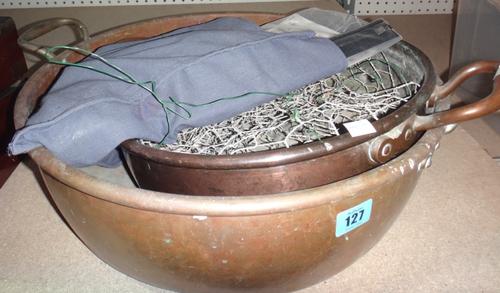 A twin handled copper pot and another.